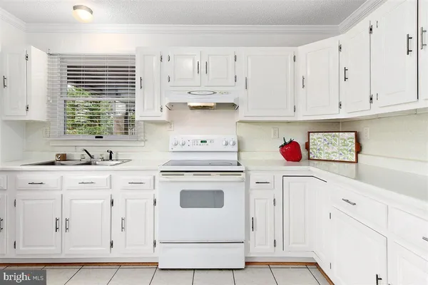 a kitchen with white cabinets and white appliances