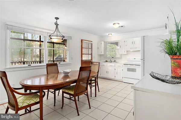 a kitchen with stainless steel appliances kitchen island granite countertop a table chairs sink and cabinets