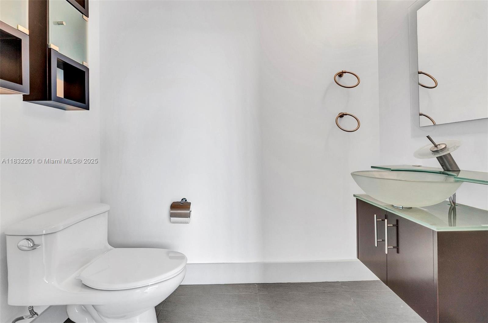 60 Southwest 13th Street, Unit 3400 Miami, FL 33130 - Photo 24 of 50 a bathroom with a granite countertop toilet sink and mirror