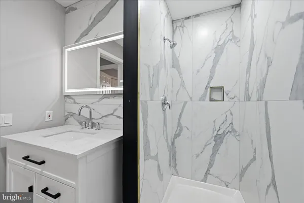 a bathroom with a sink a mirror and a shower