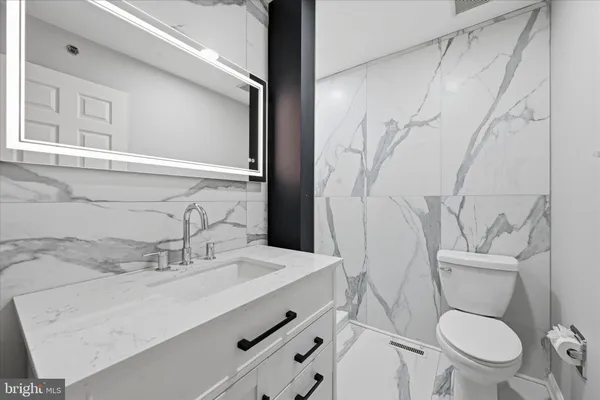 a bathroom with a toilet sink and mirror