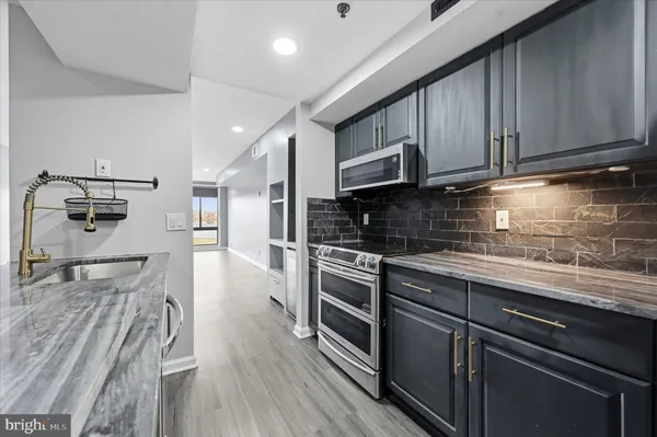 a kitchen with stainless steel appliances granite countertop wooden cabinets a stove top oven a sink and dishwasher
