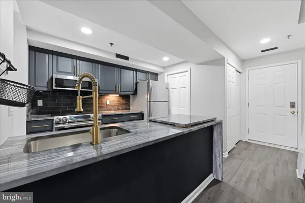 a kitchen with stainless steel appliances granite countertop a sink stove and cabinets