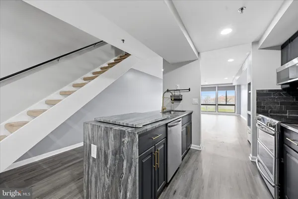 a kitchen with stainless steel appliances granite countertop a stove and a refrigerator