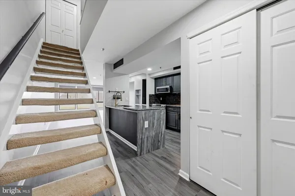 a view of a kitchen with wooden floor and electronic appliances