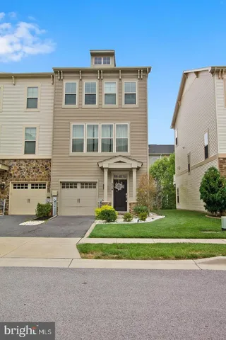 a front view of a house with a garden and trees