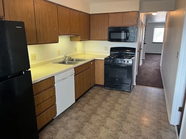 a kitchen with a stove top oven a sink and a refrigerator