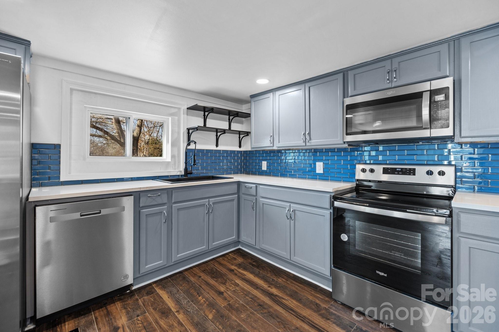 a kitchen with granite countertop cabinets stainless steel appliances and a window