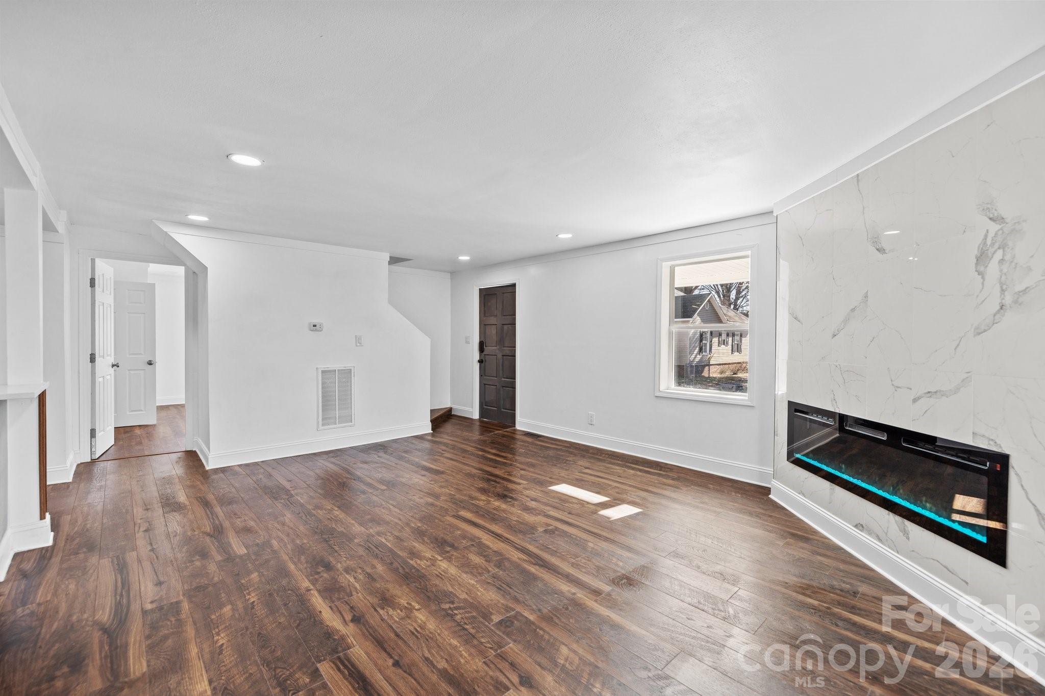 306 Ridge Street Stanley, NC 28164 - Photo 4 of 44 a view of an empty room with wooden floor and a window