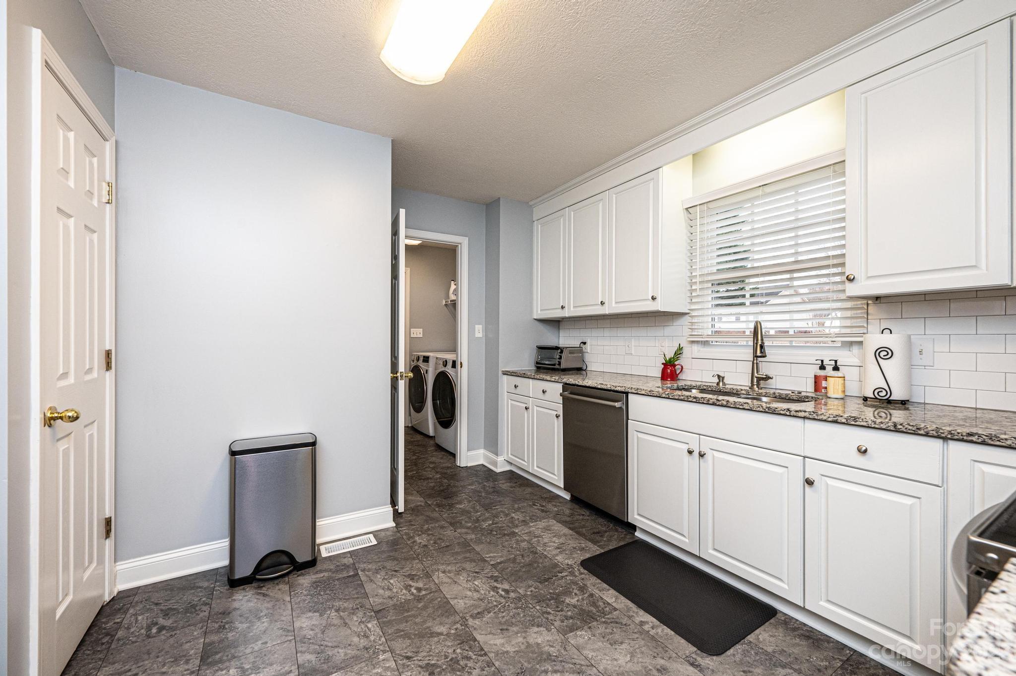 4875 Water Wheel Drive Conover, NC 28613 - Photo 11 of 33 a kitchen with granite countertop white cabinets and white appliances