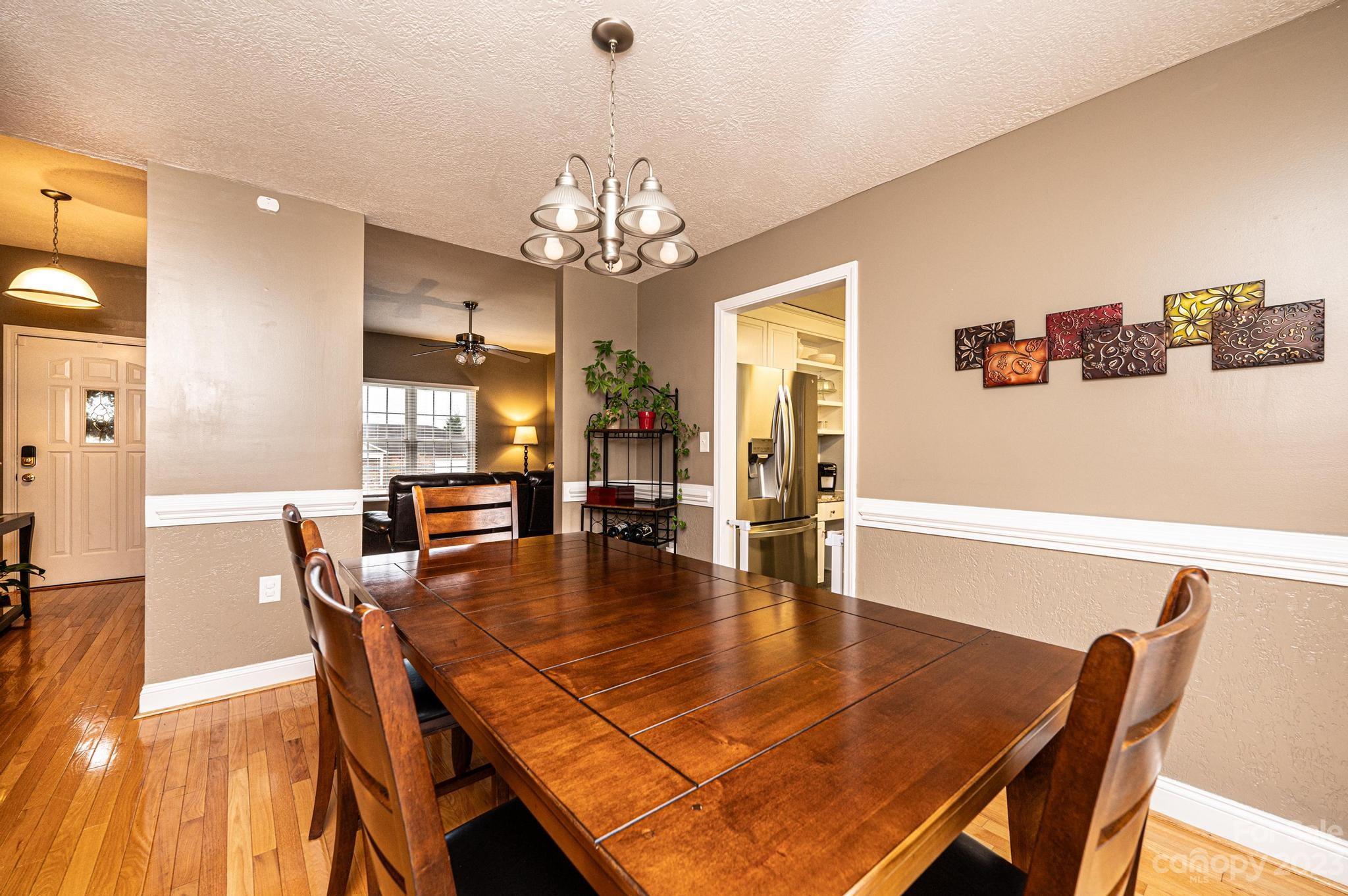 4875 Water Wheel Drive Conover, NC 28613 - Photo 10 of 33 a dining room with wooden floor a chandelier a wooden table and chairs