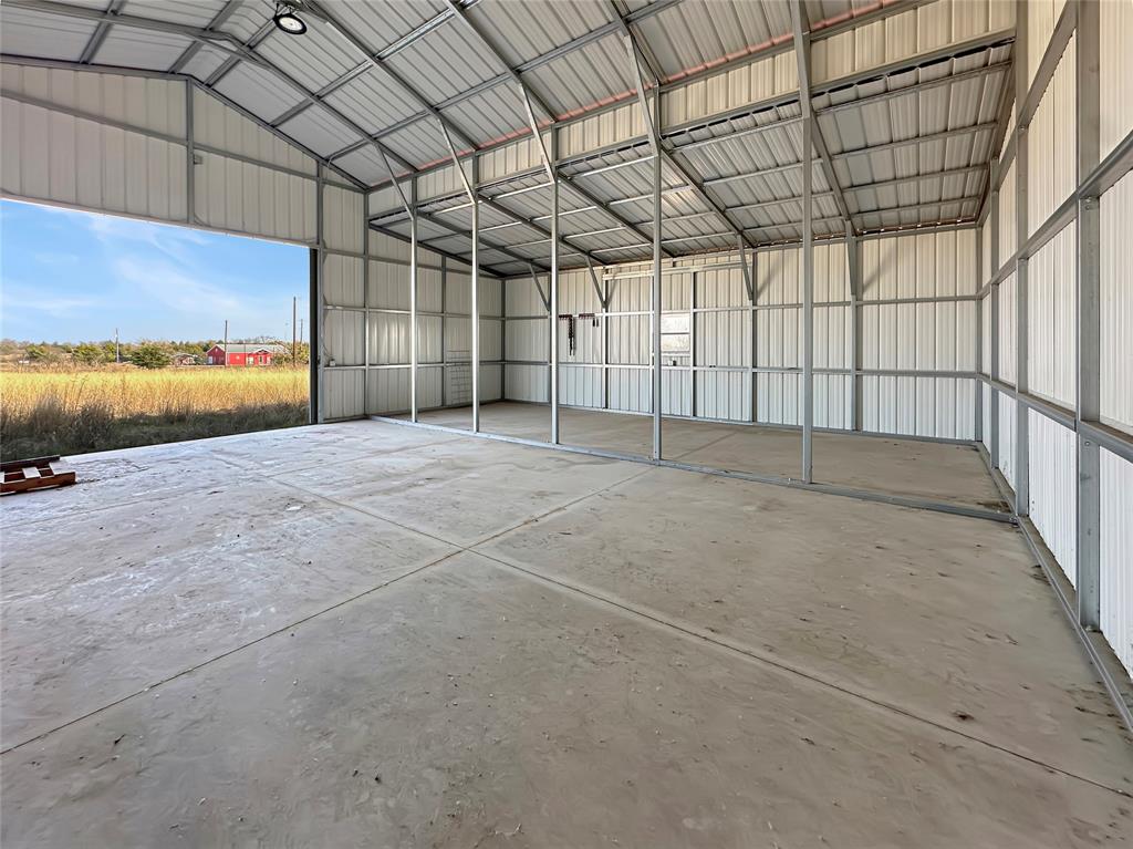 501 County Road 501 Blue Ridge, TX 75424 - Photo 8 of 27 Spacious main interior with concrete flooring, high vaulted metal ceiling, and steel framing designed for flexible agricultural or storage use.