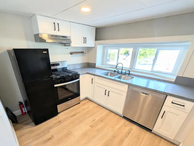 a front view of a house with a yard and potted plants