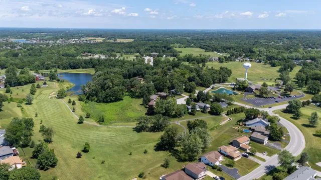 an aerial view of residential houses with outdoor space and trees