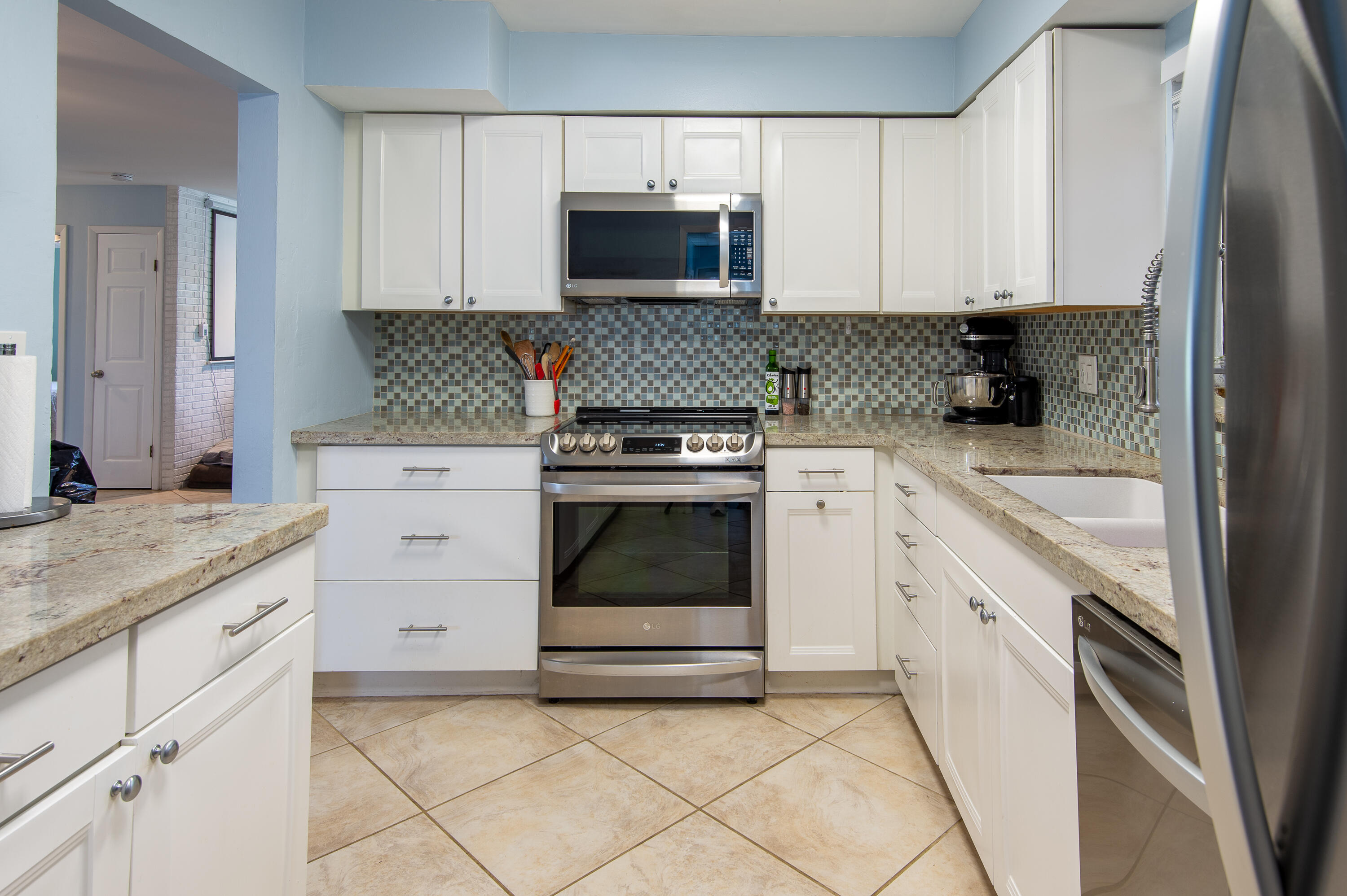 34 Key Haven Road Key West, FL 33040 - Photo 20 of 45 a kitchen with granite countertop white cabinets and stainless steel appliances