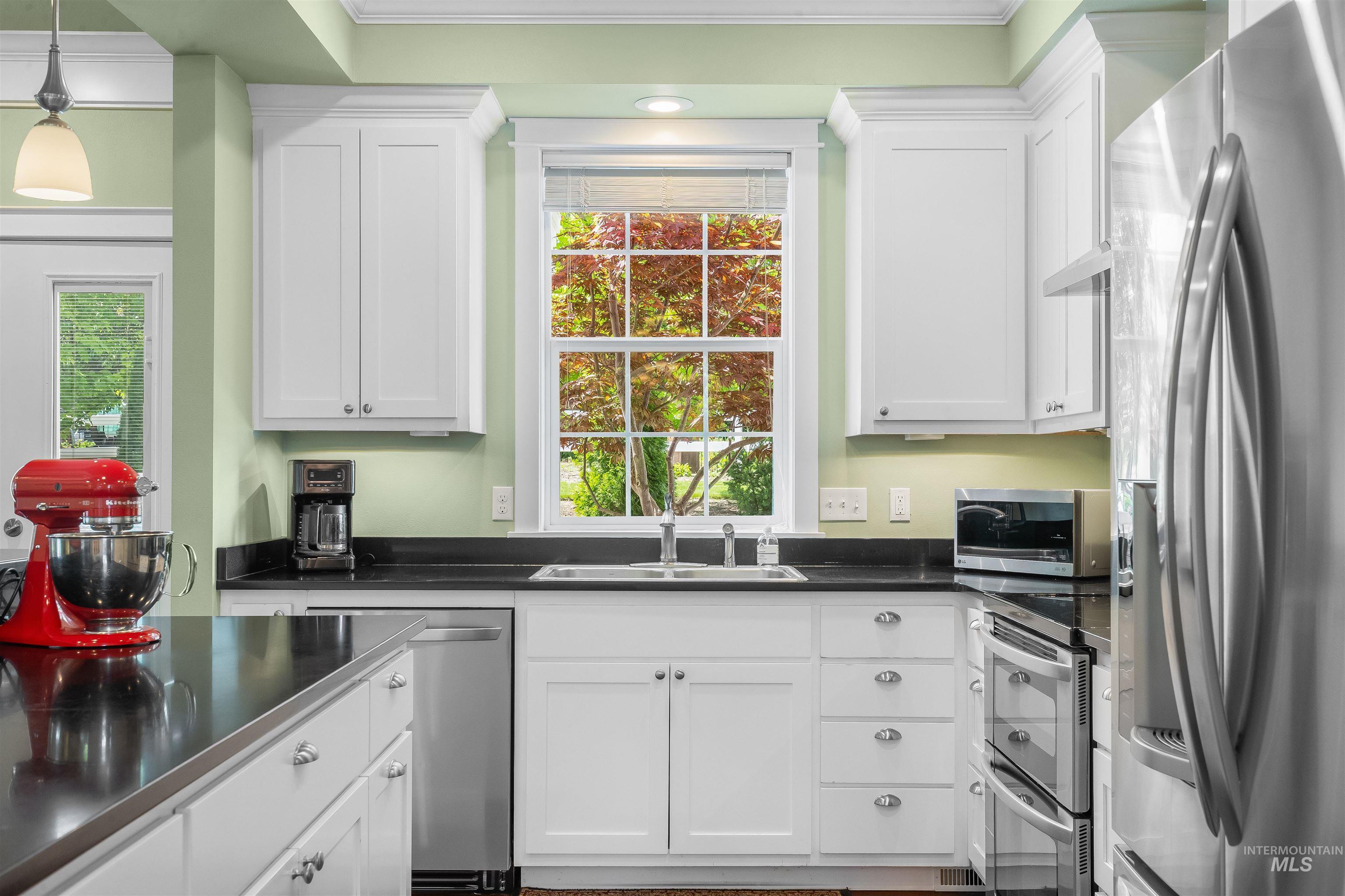 1617 Pine Cone Road Moscow, ID 83843 - Photo 10 of 44 Kitchen featuring white cabinetry with silver hardware, dark countertops, a stainless steel double oven, and a stainless steel refrigerator