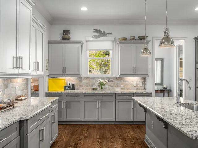 a view of a white house with large windows and plants
