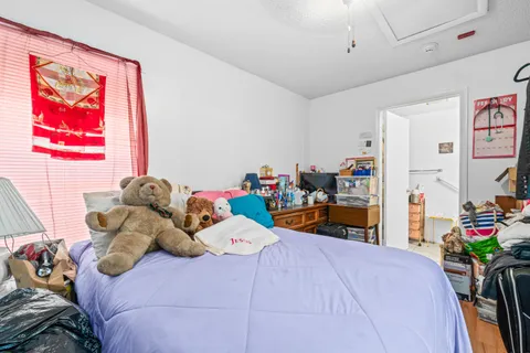 a bedroom with bed and a large window