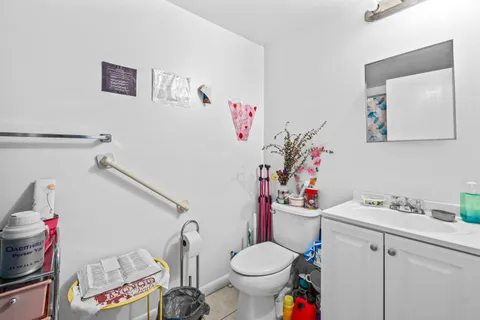 a bathroom with a sink toilet vanity and window