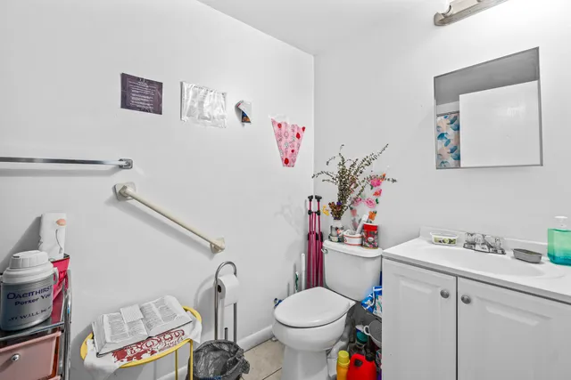 a bathroom with a sink toilet vanity and window