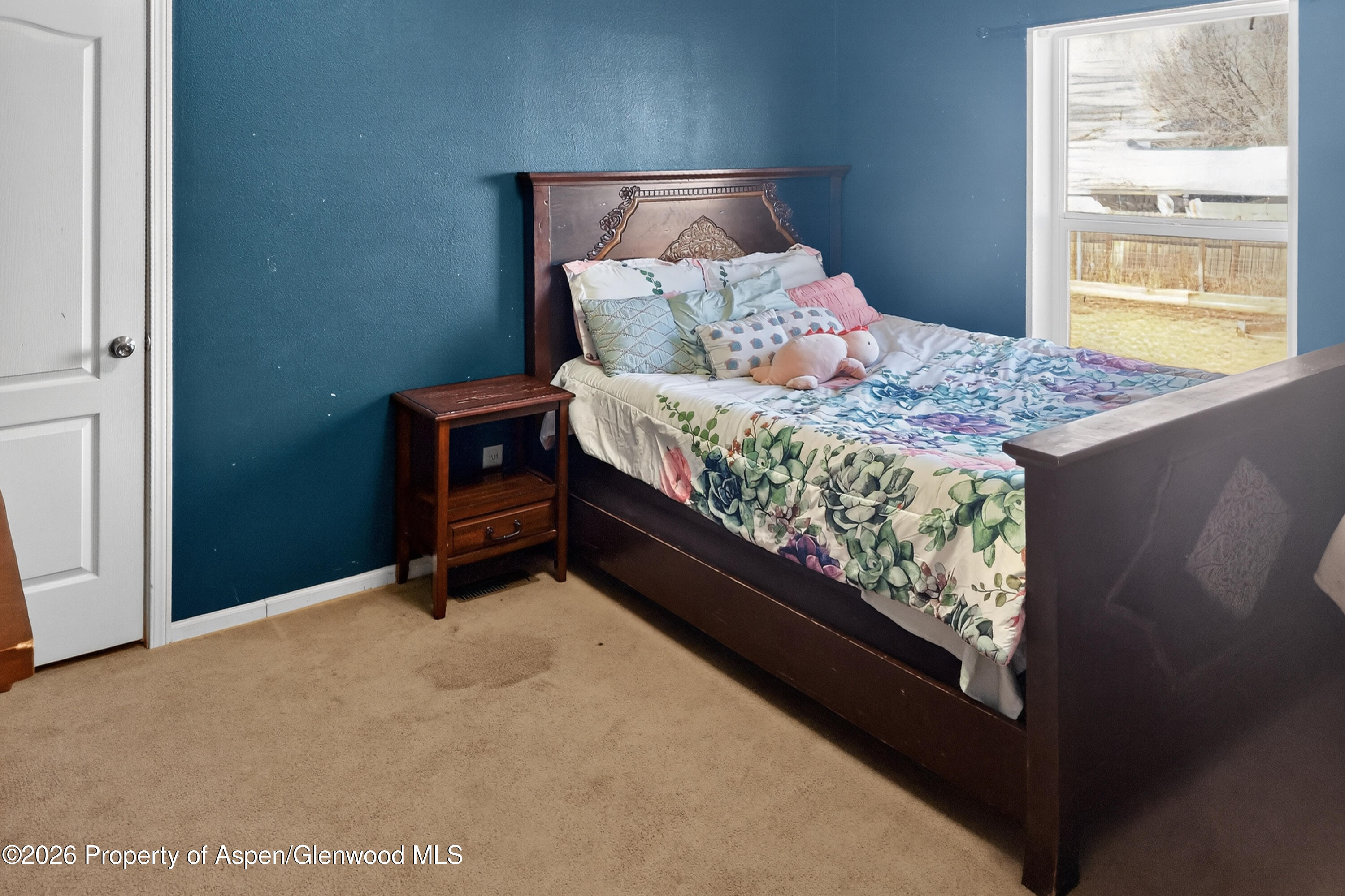 93 Remington Street Rifle, CO 81650 - Photo 20 of 25 a bed sitting in a bedroom next to a window