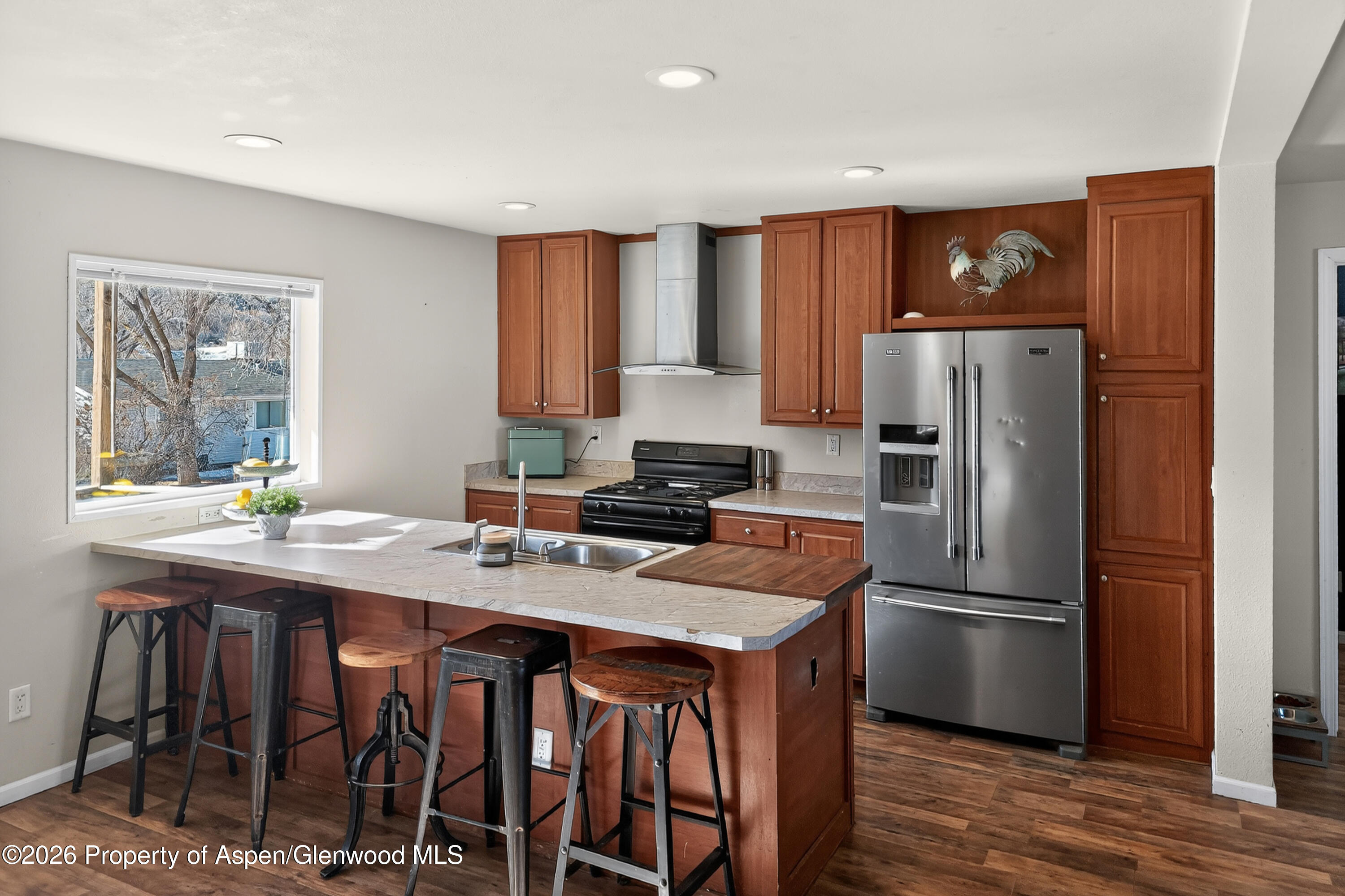 93 Remington Street Rifle, CO 81650 - Photo 5 of 25 a kitchen with stainless steel appliances granite countertop a refrigerator a stove a sink a dining table and chairs