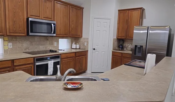a kitchen with stainless steel appliances granite countertop a stove a refrigerator and a microwave