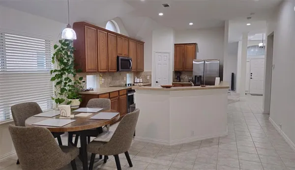 a kitchen with a table chairs sink and cabinets