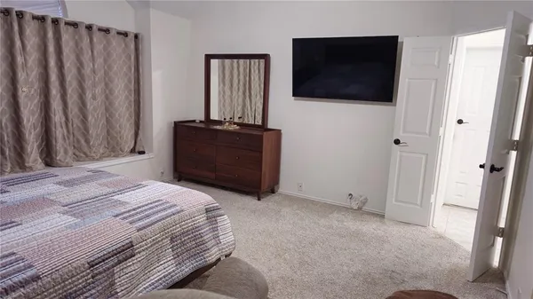 a bedroom with a bed and a flat screen tv