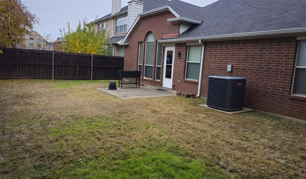 a view of a house with a backyard and wooden fence