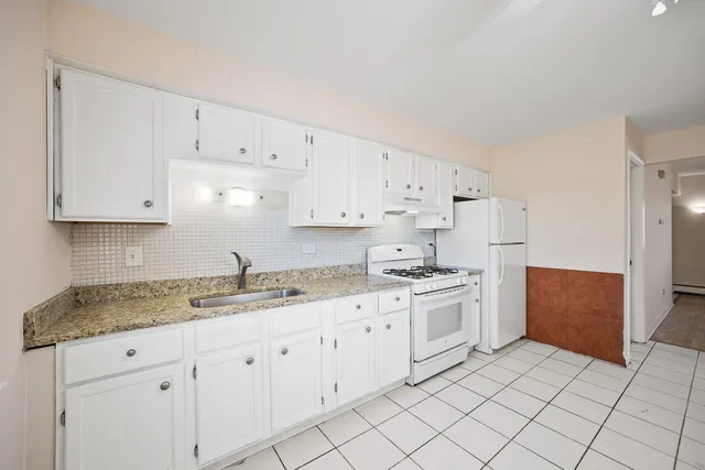 a kitchen with white cabinets sink and white appliances
