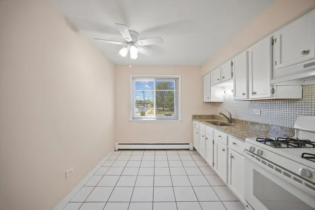 a kitchen with a stove a sink and cabinets
