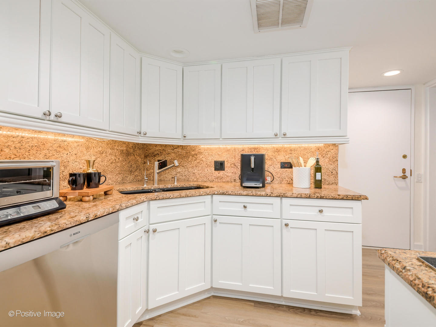 260 East Chestnut Street, Unit 2507 Chicago, IL 60611 - Photo 8 of 22 a kitchen with white cabinets sink and dishwasher