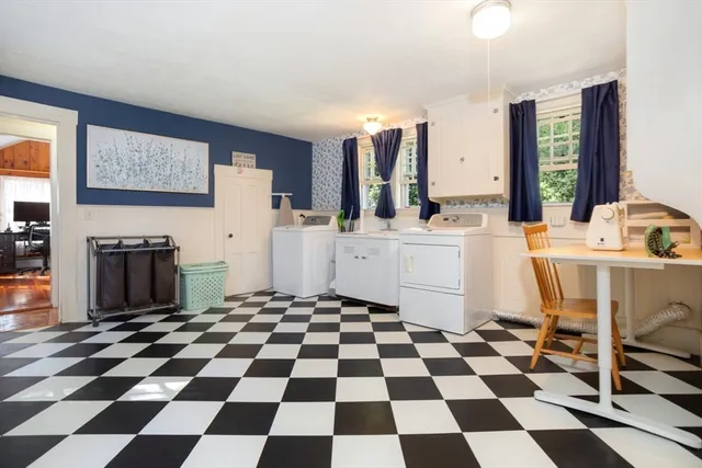 a room with a black white checkered floor with a gaming machine and appliances