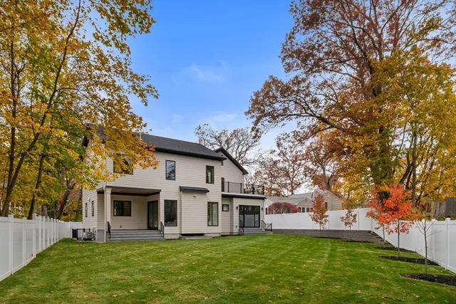 a front view of a house with a garden and trees
