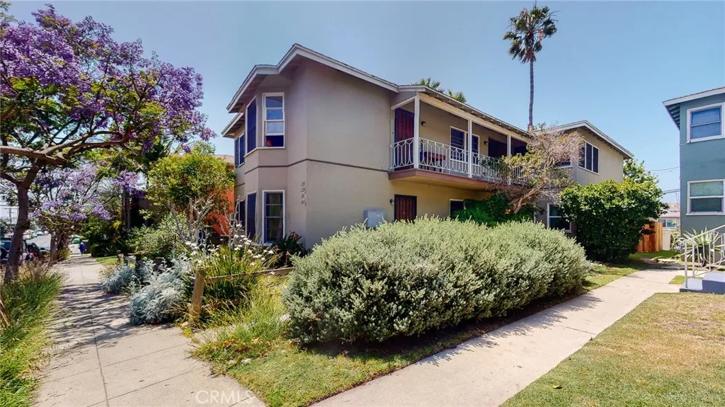 a front view of a house with a yard and potted plants