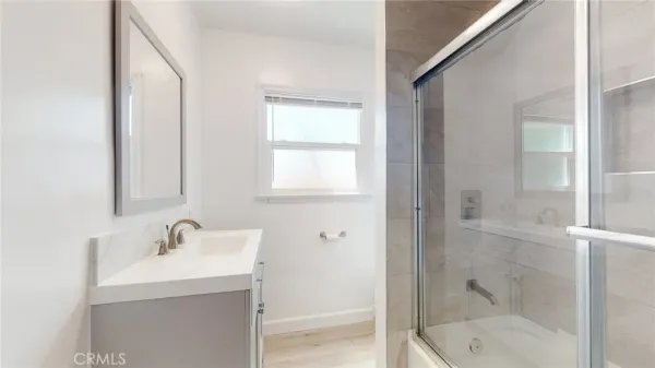 a bathroom with a shower sink and mirror