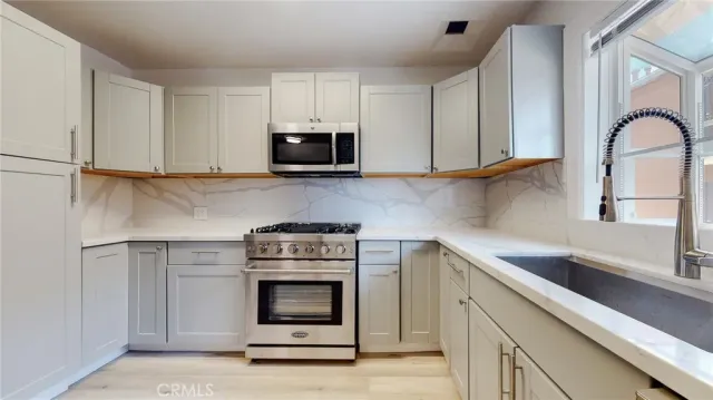 a kitchen with white cabinets stainless steel appliances and sink