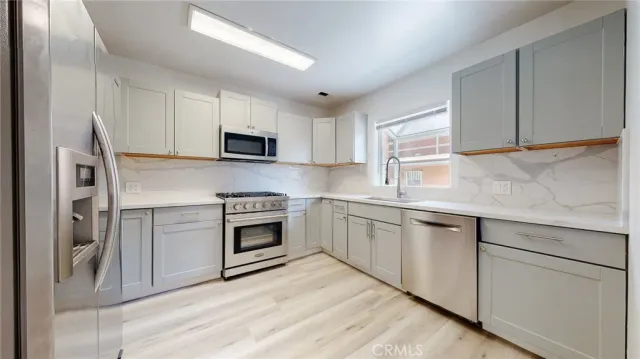 a kitchen with cabinets appliances and a sink