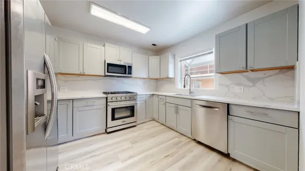 a kitchen with cabinets appliances and a sink