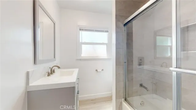 a bathroom with a shower sink and mirror