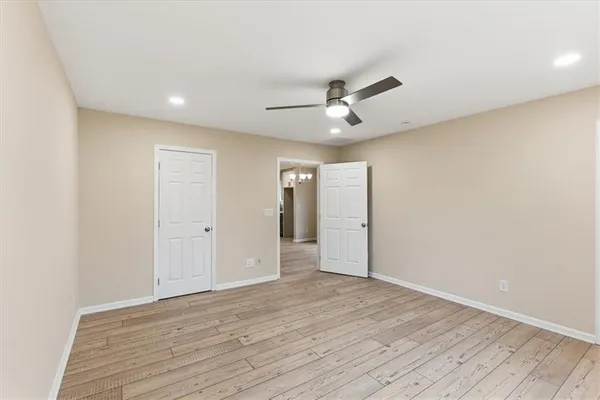 a view of empty room with wooden floor and ceiling fan