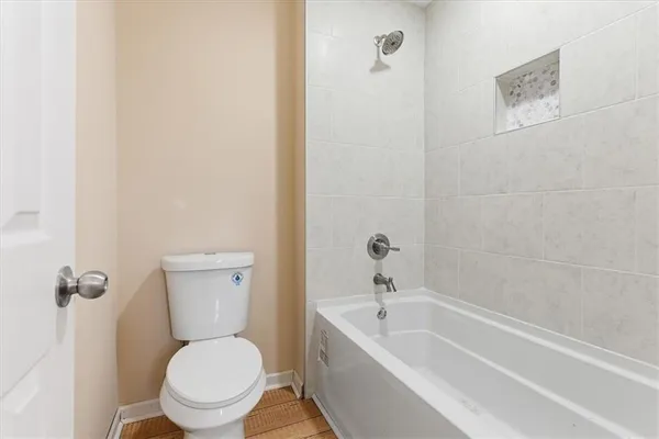 a white toilet sitting next to a bathtub