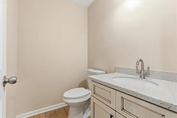 a bathroom with a granite countertop toilet and sink