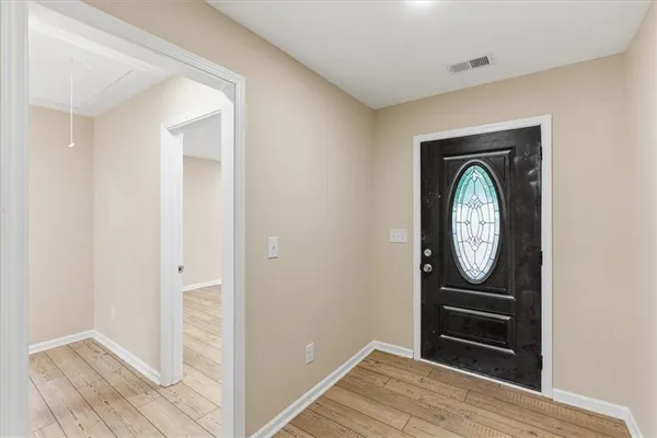 a view of a livingroom with wooden floor and a hallway
