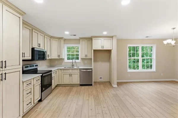 a kitchen with a sink wooden floor cabinets and appliances