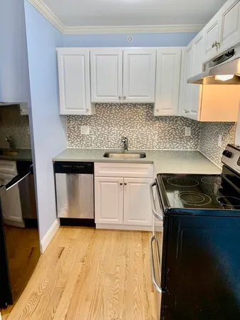 a kitchen with granite countertop a sink stove and cabinets