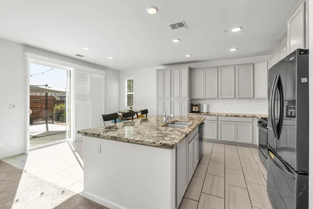 a kitchen with appliances cabinets and chairs