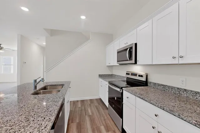 a kitchen that has a sink stainless steel appliances and cabinets