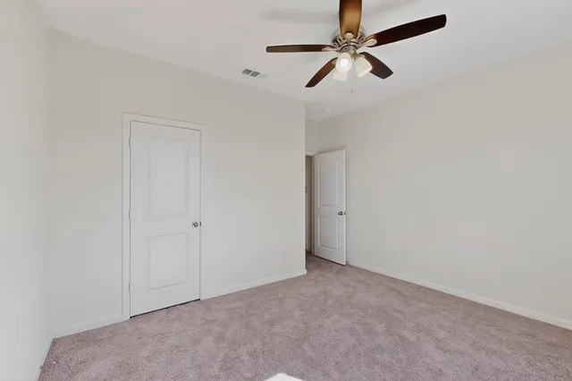 an empty room with a window and a fan